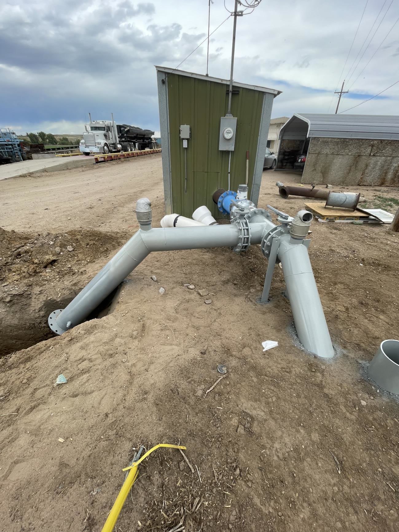 Painted steel pipeline tie-in with valves dropping into a trench